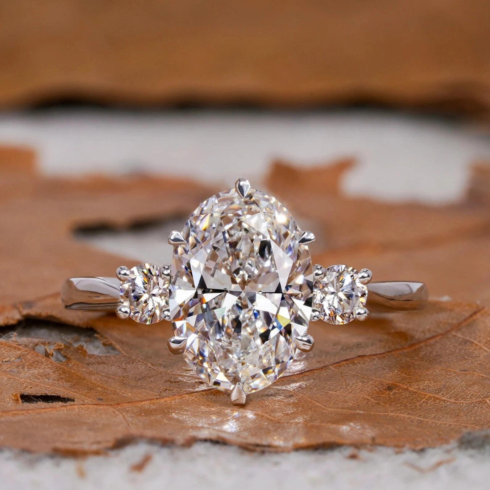 733e26c911aeb750c80e0509adef4463 3-Carat Lab-Grown Oval Diamond Three-Stone Ring: 0.3ct Round Accents in 14K White Gold - Image 1